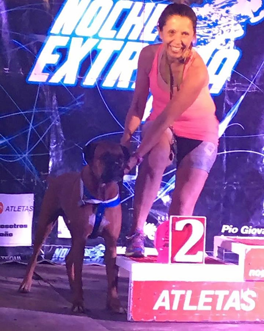 Lili y Lolo, su boxer, sobre el podio de una carrera nocturna, en el segundo puesto